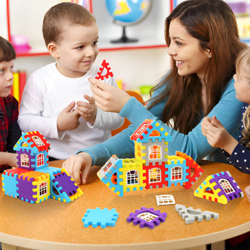 Trois enfants de 3-6 ans autour d'une table avec leur éducatrice explorant BuildCréa en groupe. Structures colorées multiples rouge, bleu et jaune favorisant l'apprentissage collectif. Environnement éducatif stimulant la créativité, la communication et le travail d'équipe.