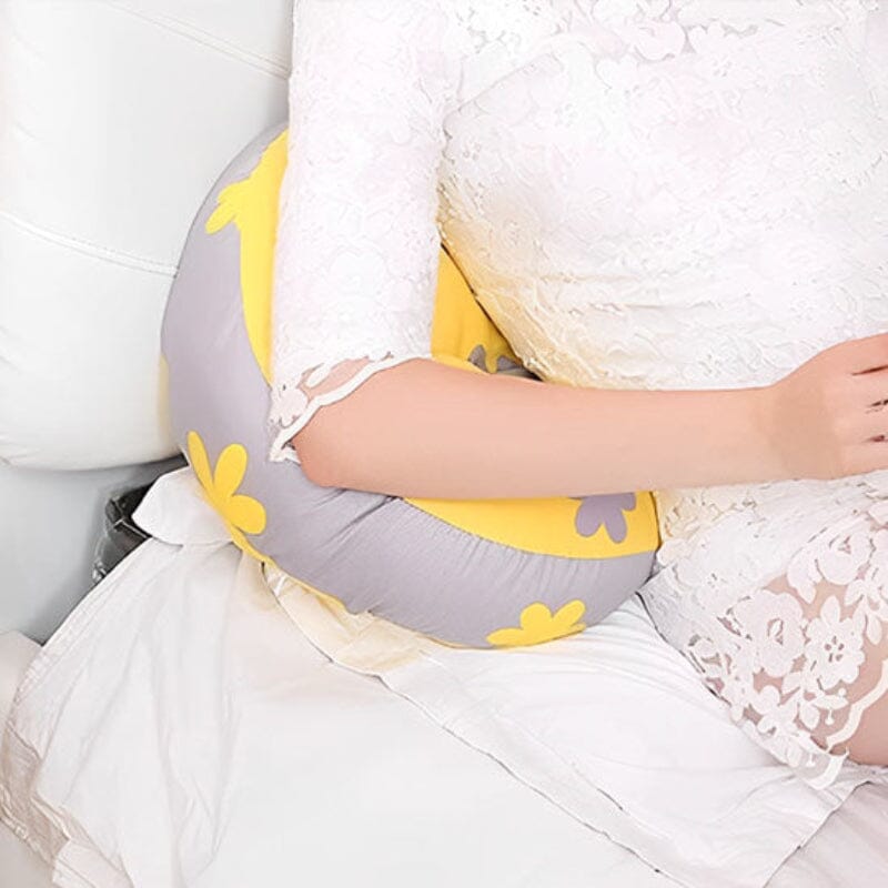 Femme enceinte utilisant coussin de grossesse ergonomique en position relaxation pour support dorsal optimal
