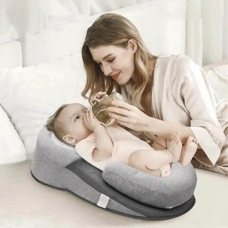 Mère nourrissant bébé au biberon sur coussin anti-reflux incliné dans environnement domestique confortable et sécurisé