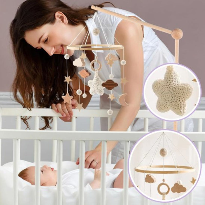 Maman installant un mobile bebe artisanal avec lapin en crochet au-dessus du lit de bébé - Éléments naturels en bois et crochet
