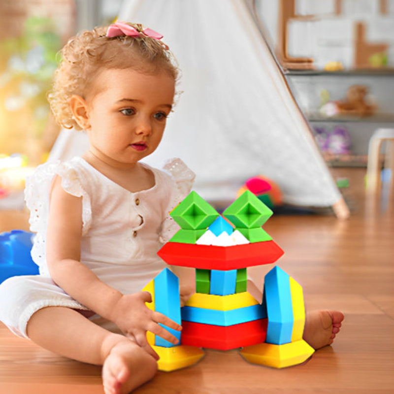 Fillette aux cheveux bouclés jouant blocs de construction équilibrés - apprentissage spatial