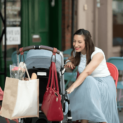 CrochéBalade en utilisation - maman avec poussette et sacs accrochés aux attaches cuir