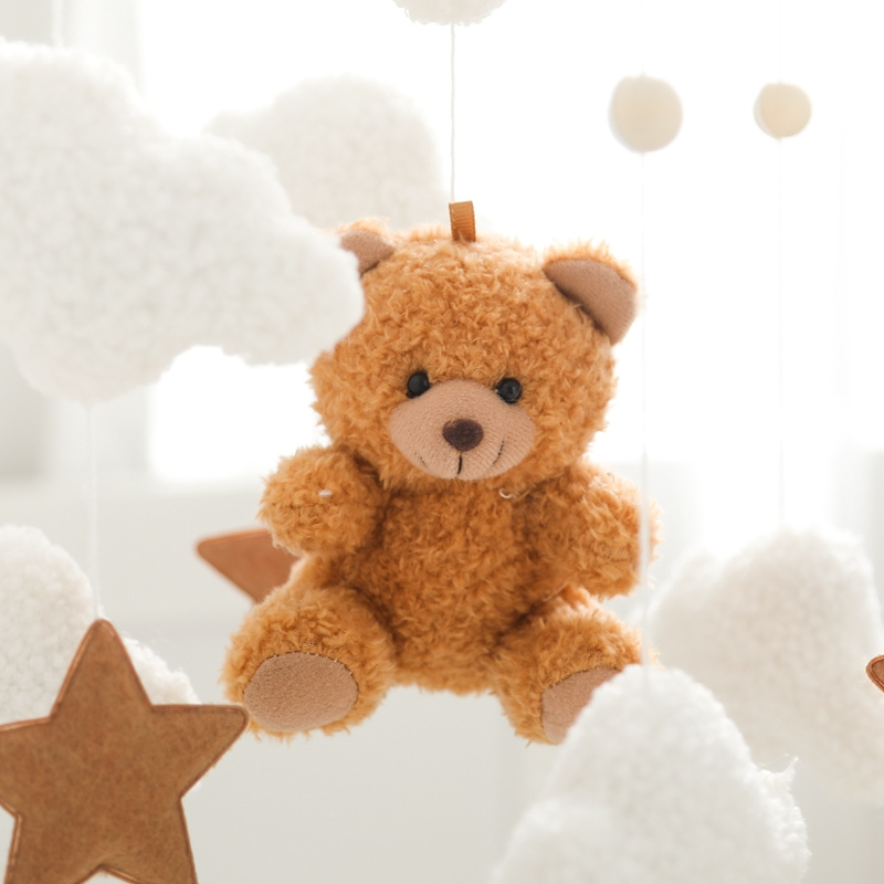 Mobile bebe gros plan nounours marron doux avec nuages moelleux et etoiles stimulation visuelle
