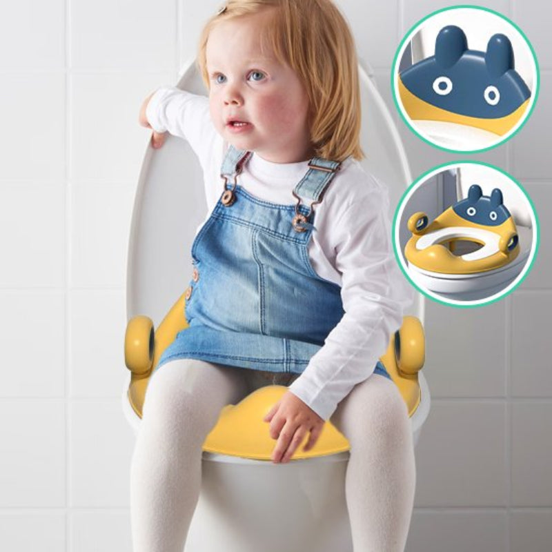 Réducteur de toilette pour enfant avec poignées ergonomiques, petite fille blonde en salopette jean assise confortablement